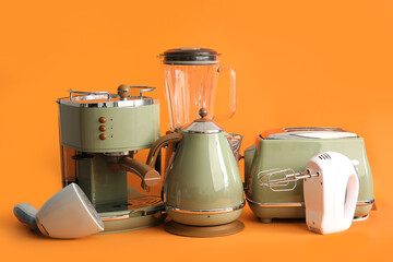 Set of modern household appliances on orange background