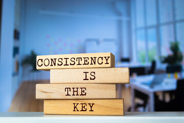 Wooden blocks with words 'CONSISTENCY IS THE KEY'. Business concept