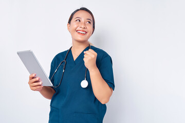 Smiling young Asian woman nurse working wearing blue uniform holding a digital tablet and showing...