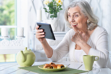 Obraz na płótnie Canvas Portrait of senior woman with tablet pc