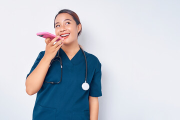 Beautiful smiling young Asian woman professional nurse working wearing a blue uniform talking on...