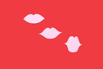 Pink paper lips on red background