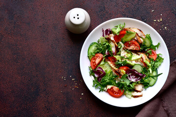 Fresh salad leaves with vegetables and grilled chicken fillet. Top view with copy space.