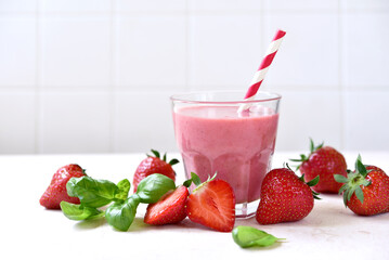 Fresh banana strawberry smoothie with basil in a glass.