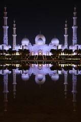 Exterior view at night of illuminated Sheikh Zayed Grand Mosque in Abu Dhabi, UAE
