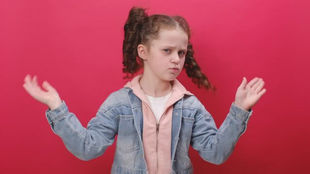 Portrait of preeten girl kid wearing denim jacket smelling something stinky and disgusting, intolerable smell, holding breath with fingers on nose, isolated on red studio background. Bad smell concept