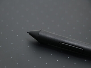closeup of a black digital stylus touch pen tool on a sketching tablet used by artists and designers