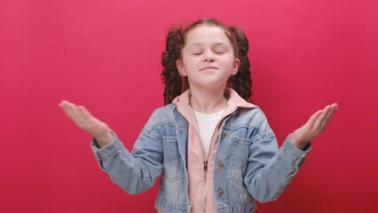 Portrait of happy little girl kid stretching relaxing, smiling child with eyes closed feel peaceful breathing fresh air, good pleasant smell, posing isolated over red color background wall in studio