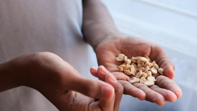 men eating peeled peanuts close up