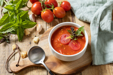 Bowl of tomato cream soup with basil and croutons on a rustic table. Vegan soup puree tomatoes. Healthy diet low carb.