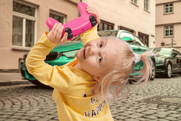 A little girl holds a game joystick in her hands