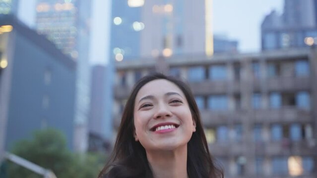 Young beautiful Chinese woman walking on the street of Chengdu with smile on her face