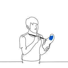 man paints a white sneaker with blue paint using a brush - one line drawing vector. concept shoe customization, homemade shoes, custom shoes