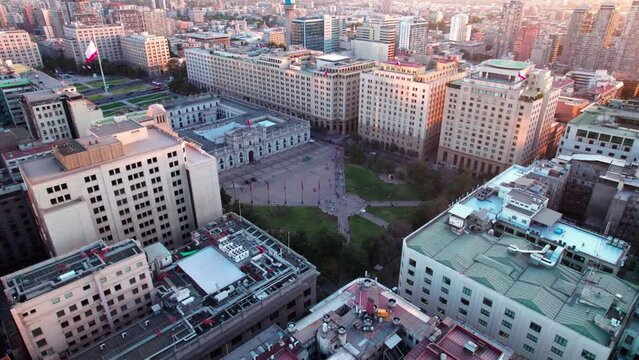 Aerial revealing shot of the Barrio Cívico, La Moneda with flags flying in the square