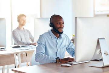 Call center, computer and online with black man in office for customer service, technical support and advice. Technology, contact us and communication with employee operator in help desk agency