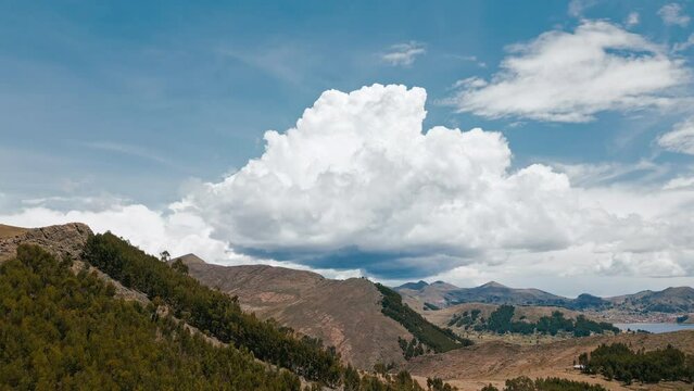 Experience the stunning beauty of the Titicaca region's agricultural terraces against a backdrop of a massive cloud.