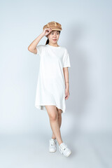 A posing young asian woman with her white blank shirt dress and a hat