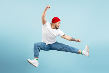 Handsome asian man, fighter with stylish tattoo, training isolated on blue background. Korean...