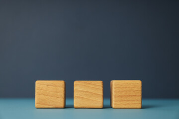 Three wooden cubes on blue table, space for text