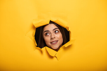 portrait of woman tearing yellow background