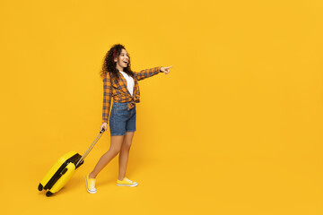 Fototapeta na wymiar Young woman with suitcase on yellow background