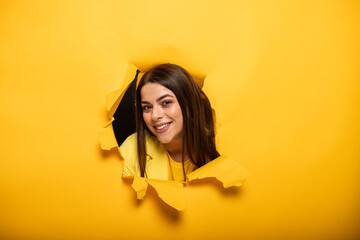 portrait of woman tearing yellow background