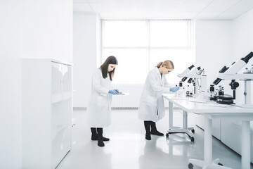 Professional smart women working in the laboratory looking at samples through microscope. Doing analysis and working. Generative AI.