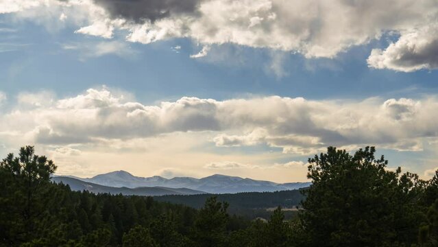 Mt Evans Blue Sky Timelapse spring time clouds rolling over mountain landscape with sun rays and snow on peaks