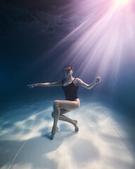 Fototapeta na wymiar A girl in a diver mask underwater in the pool in the water