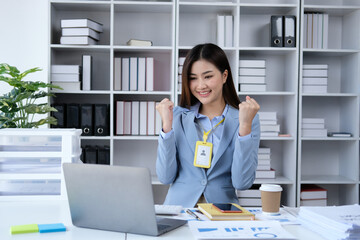 Beautiful Asian girl celebrate with laptop, success happy pose. E-commerce, university education, internet technology, or startup small business concept. Modern office or living room with copy space