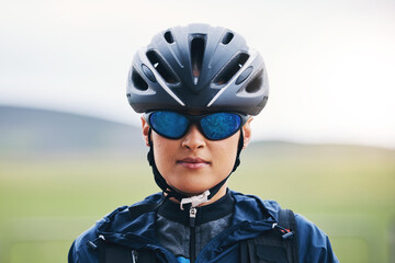 Portrait, cycling or girl athlete in nature for exercise, workout or training for triathlon sports or fitness. Woman cyclist, helmet gear or face of biker on break exercising for cardio endurance