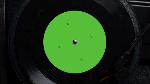 Close up of a vintage retro vinyl record with green sticker rotating. Top view. Old fashioned music. Needle gramophone. 4K ProRes