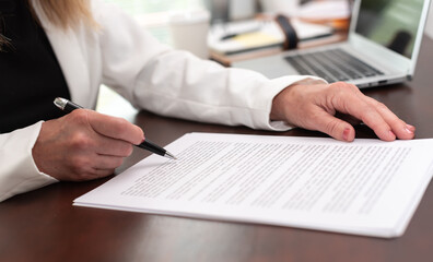 Businesswoman reading and checking document (Lorem ipsum text used)