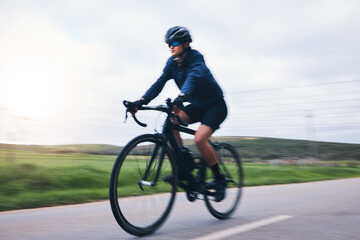 Woman, bicycle and nature road with motion blur for fitness, health and eco friendly travel on summer adventure. Cycling girl, bike and fast at workout, training and journey on countryside street