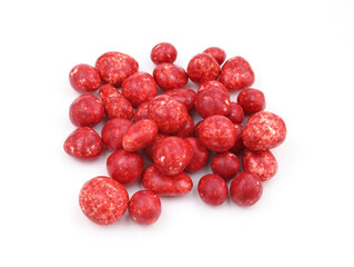 Red candies with icing on a white background. White chocolate with strawberry sweets for tea. Round candies with colored icing. Heap of sugared almonds