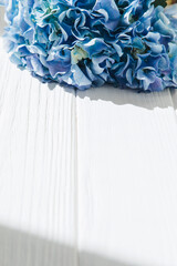 Blue hydrangea on a white wooden table. Flowers background, close-up. Top view