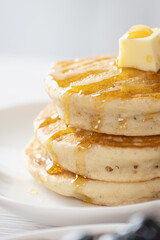 Pancake with butter and honey maple syrup set on white cafe table. - 594565248