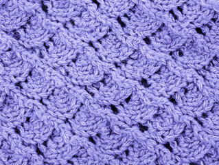 Purple Knitting pattern close-up. Knitting is an easy pattern for beginners. Texture of a knitted sweater. Warm thread pattern in the shape of a fan