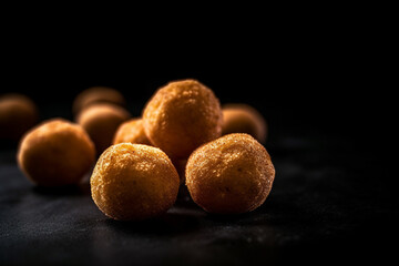 fried potato balls on a black background