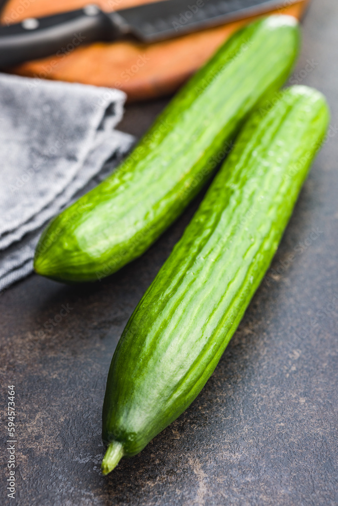 Sticker fresh green cucumbers on kitchen table.