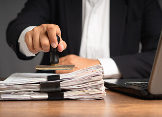 Businessman in a suit stamped for approved documents while sitting in the office