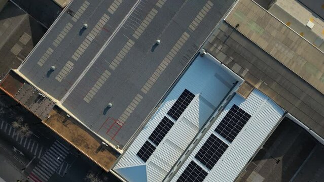 Aerial view of a solar panel covered industrial warehouse in an industrial park
