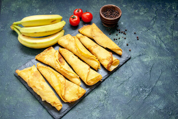 front view yummy rolled pancakes with bananas on dark background cake dough hotcake color meal pastry sweet pie meat