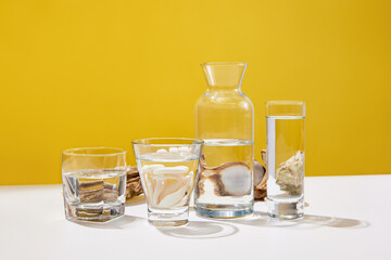 Still life with seafood, oysters and glasses with water on white table over yellow studio background. Sea, ocean harvest. Royal menu