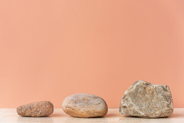 Fototapeta na wymiar A row of three natural stones, arranged in size from smallest to largest, empty space. The concept of growth, development. Podium, blank for the presentation of goods.
