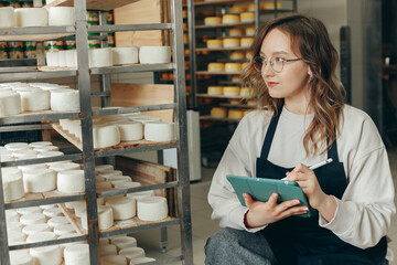 Young Farm Female Owner Controls Maturing Process of Goat Cheese Heads