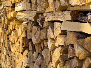 Neatly stacked firewood for the stove is lying in the park. Soft focus