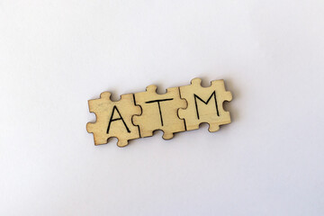 The acronym ATM, which stands for At The Moment. The letters written on the puzzles.