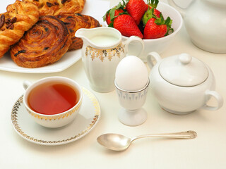 Continental breakfast with egg, tee, milk, buns, strawberry