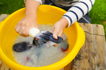 A happy caucasian 9 years boy helps her mother to hang up clothes. Development of fine motor skills through household activities. Selective focus.